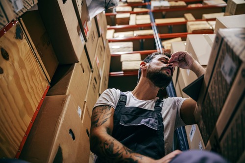 Fatigued warehouse worker taking a break