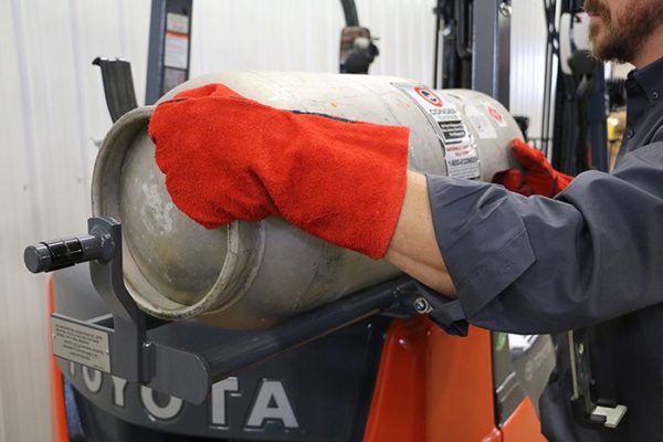 A forklift operator removing an empty LP tank