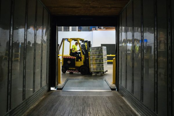 A forklift operator preparing to enter a semi-trailer