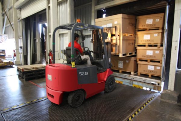 A forklift operator removing cargo from a semi-trailer