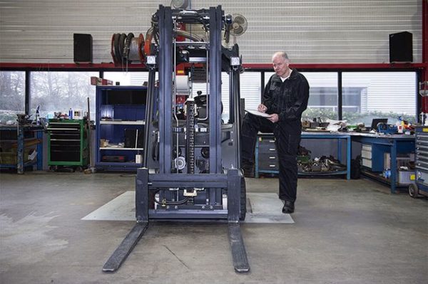 A forklift operator conducting an inspection before operating