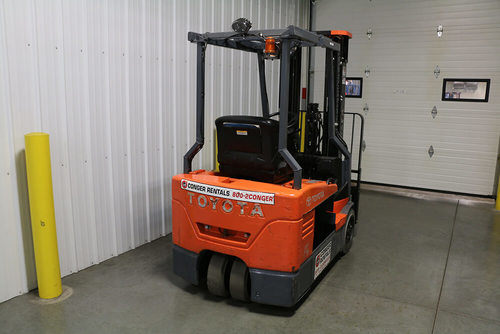 A Toyota electric 3-wheel forklift with a drive-in overhead guard installed