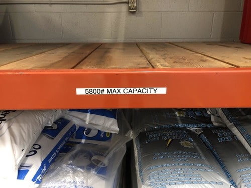 A warehouse beam labeled with the capacity