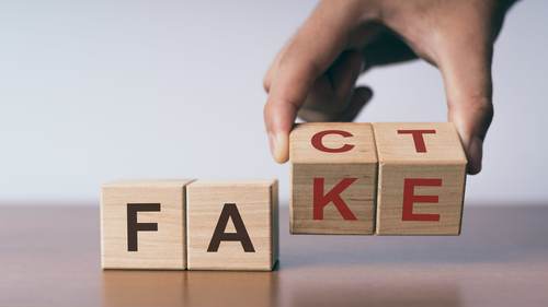 Wooden blocks spelling "fake" and "fact"