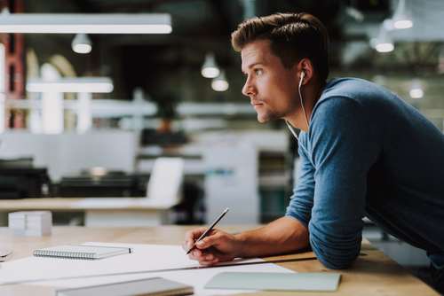 Young office worker with earbuds in