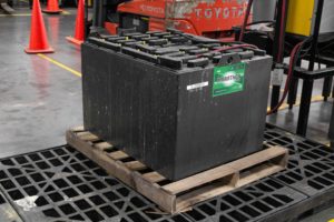Industrial forklift battery sitting on a leak containment pallet