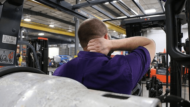 Forklift operator holding his neck in pain