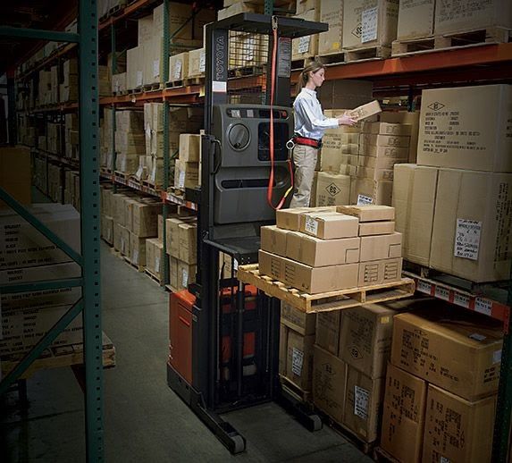 Order picker forklift with operator grabbing box from racking