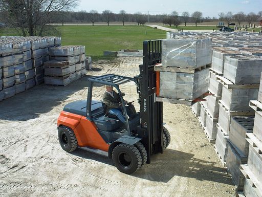 Large Toyota pneumatic forklift lifting pallets of bricks