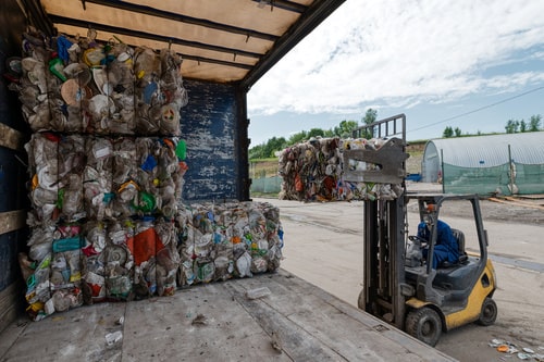 Forklift loading a semi trailer with recyclables