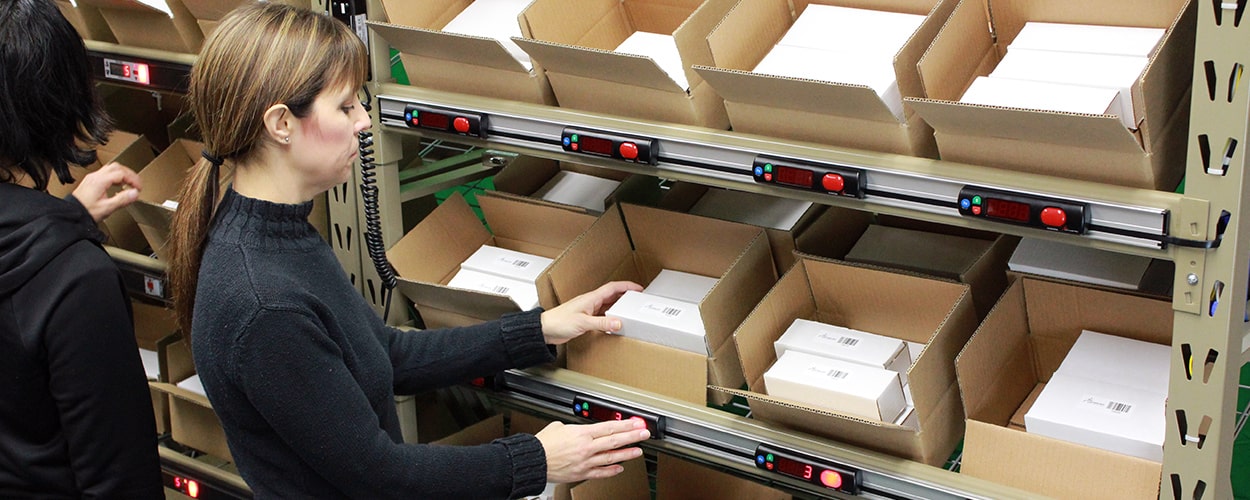 A worker fulfilling an order using a pick-to-light system