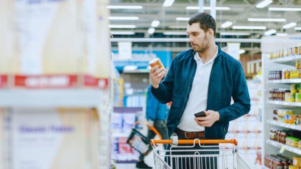 A man shopping while looking at his phone