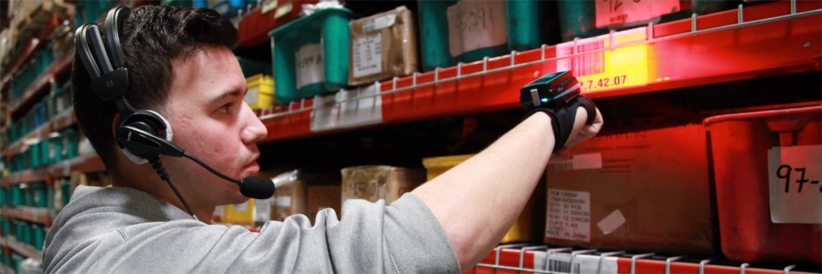 A warehouse worker picking an order using a voice picking headset