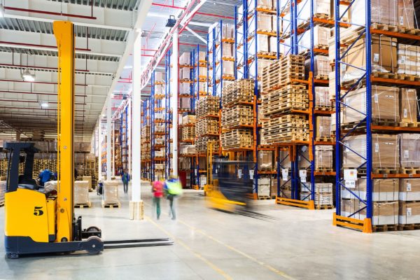 Forklifts and workers moving in a warehouse