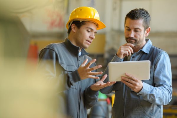Two workers discussing over a tablet