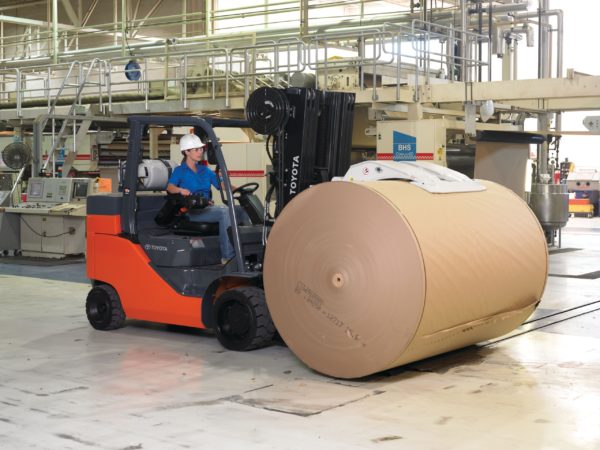 A forklift operator handling a paper roll using a Toyota Paper Roll Special forklift