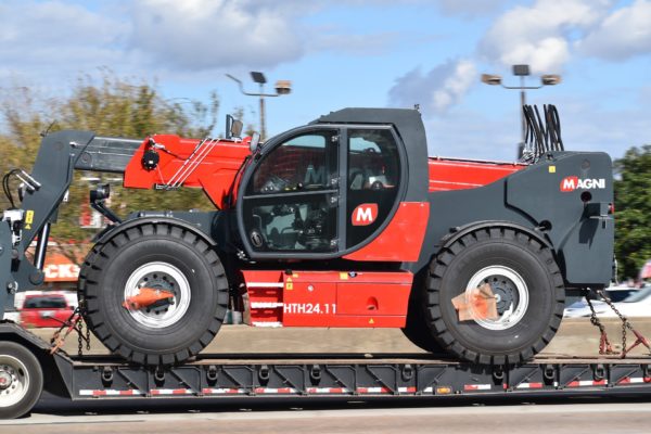 A telehandler forklift loaded on a semi trailer