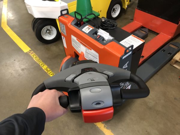 The tiller arm - used for steering - on an electric pallet jack