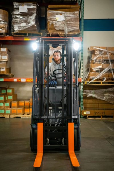 A forklift operator looking through the mast