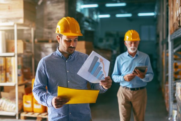 A warehouse manager reading through documents signaling growth of operations