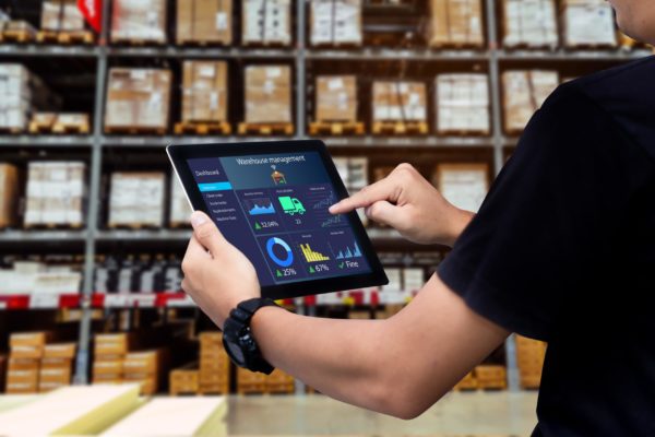 A warehouse manager using a tablet to access a warehouse management system