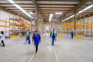 Several warehouse workers walking in different directions