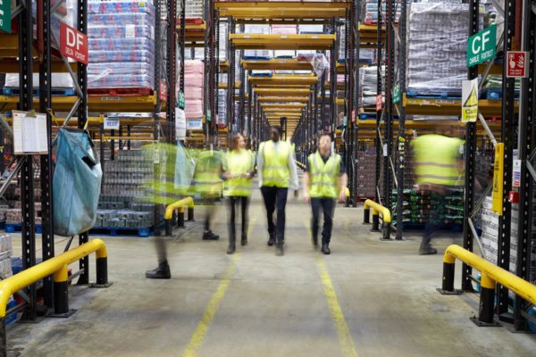 A group of warehouse workers walking within an aisle