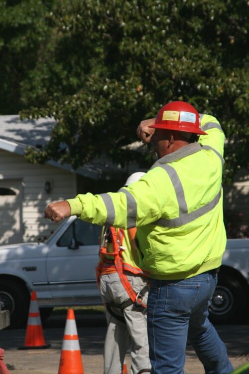 A construction worker giving hand signals to direct equipment operators