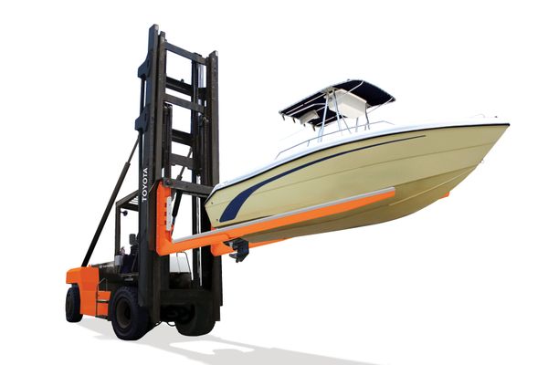A marina forklift lowering a boat into the water