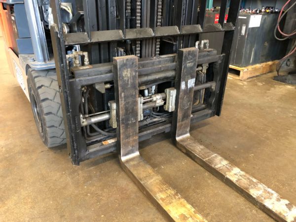 A fork positioner mounted to a Toyota electric forklift