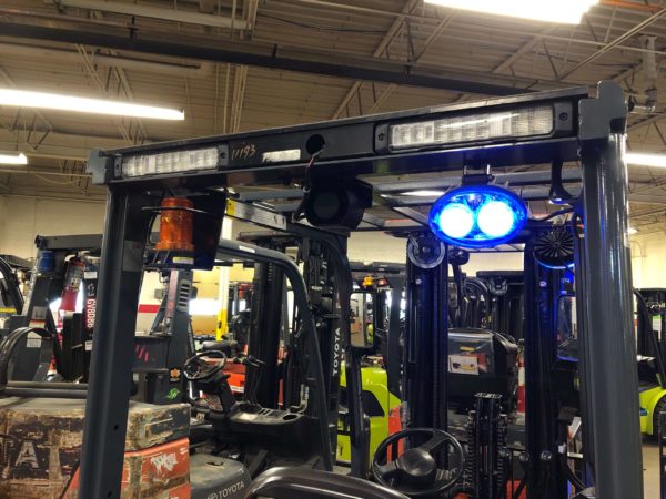 A blue warning light mounted on the back of a Toyota forklift