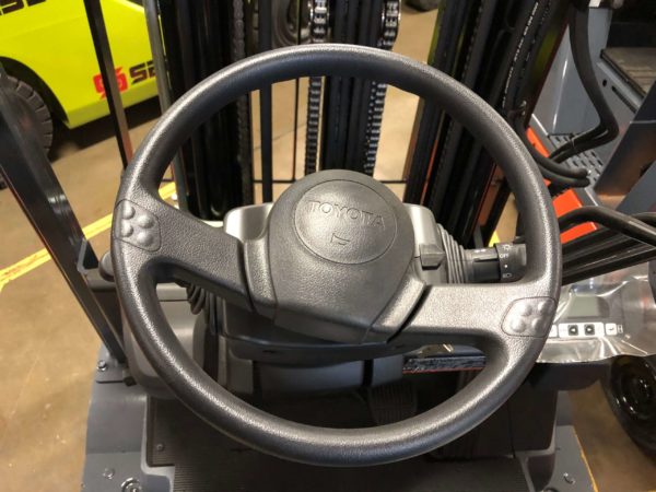 A steering wheel with a horn on a Toyota electric forklift