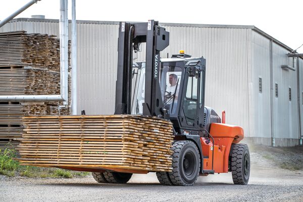 A Toyota forklift with dual tires carrying a load of lumber