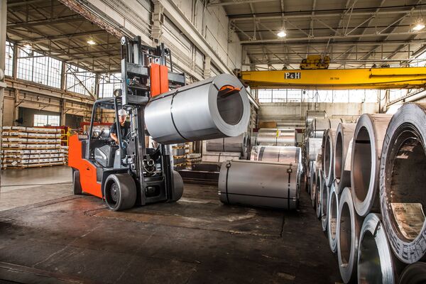 A high-capacity Toyota forklift lifting a roll of steel