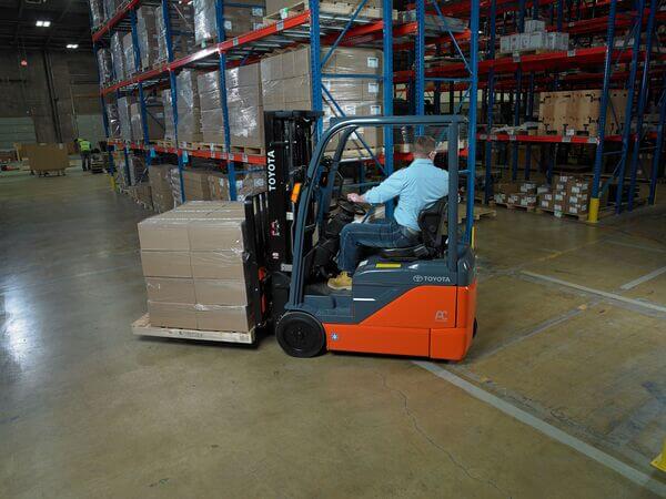 A forklift operator transporting a pallet of materials