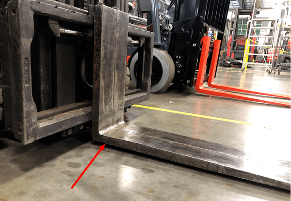 A forklift with worn fork heels