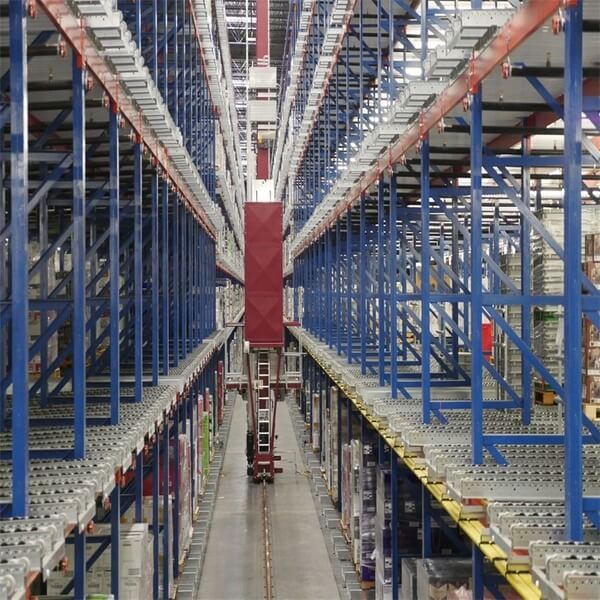 A crane moving down an aisle of pallet racking