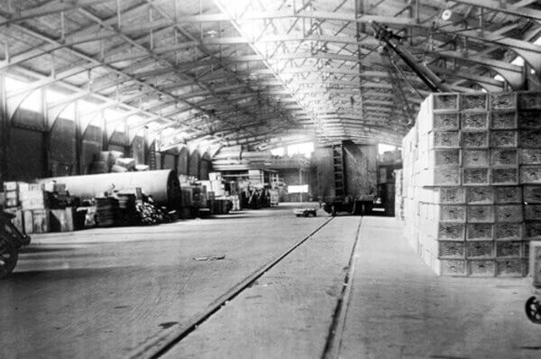 A black-and-white photograph showing a warehouse from the 1920s