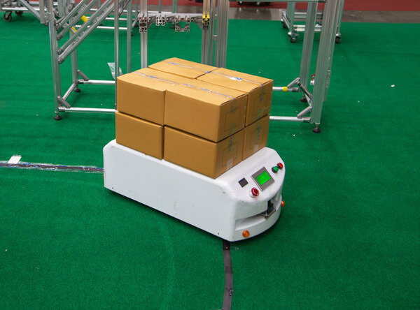 An ASRS shuttle bringing cardboard boxes to workers