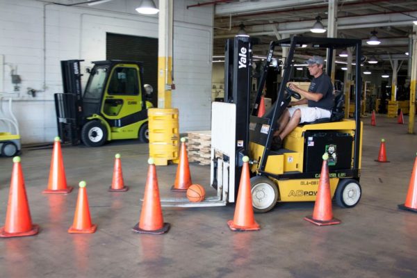 A sit-down forklift operator navigating an obstacle course during training