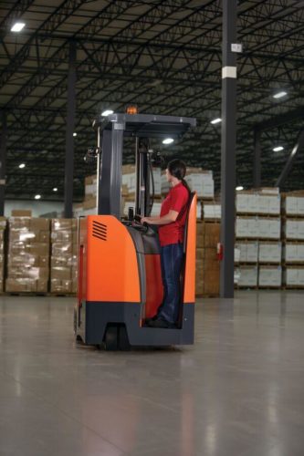 A stand-up forklift operator as viewed from the rear of the machine