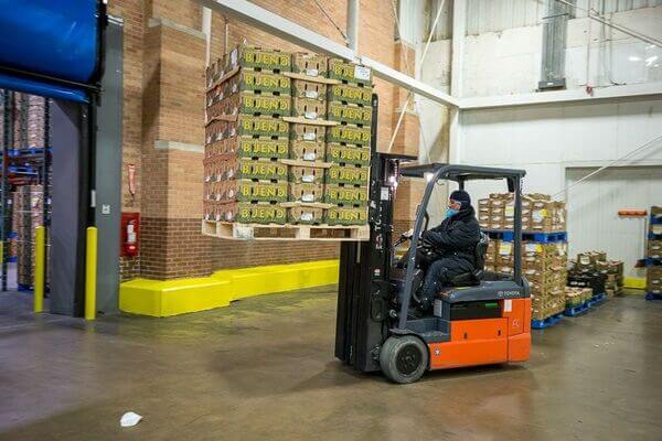A counterbalance forklift operator carrying a pallet in the air