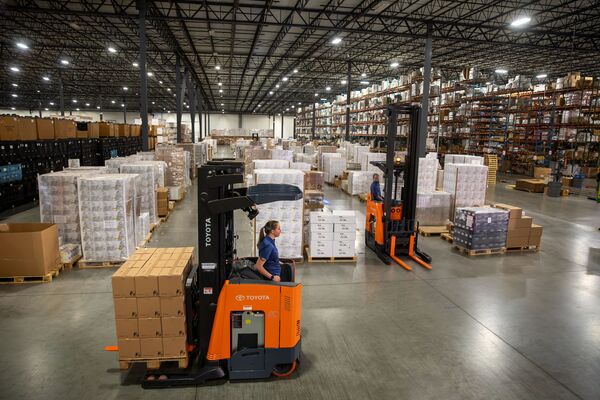 Reach truck operators driving around in a warehouse