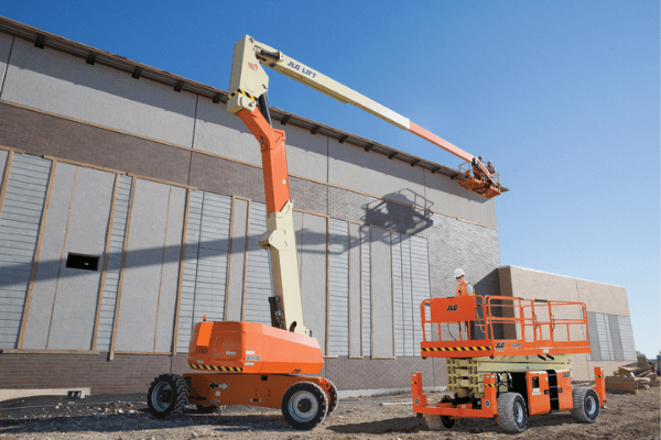 A JLG scissor lift with an operator driving next to a raised JLG boom lift