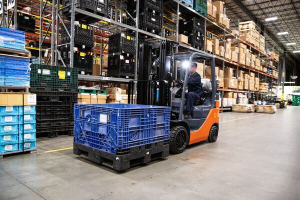 A Toyota internal combustion forklift carrying a pallet
