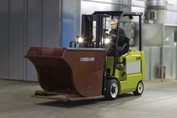 A sit-down forklift operator carrying a hopper on the forks