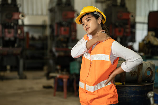 A warehouse worker rubbing their neck