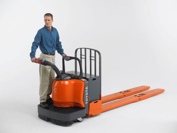 An operator standing on a Toyota electric rider pallet jack