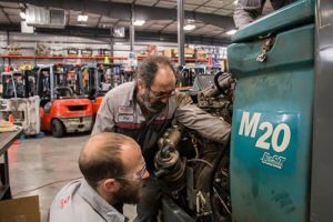 Two Conger service technicians troubleshooting a floor scrubber