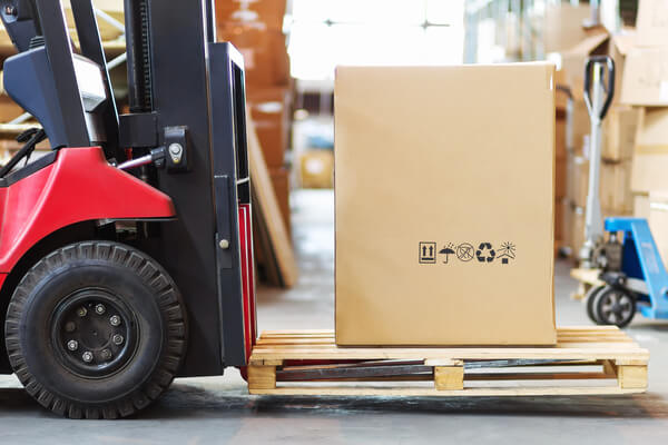 A forklift lifting a pallet slightly off the ground